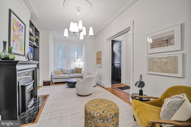 living area featuring crown molding, wood finished floors, a wood stove, a chandelier, and baseboards
