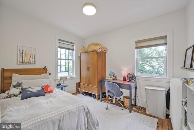 bedroom featuring wood finished floors and baseboards