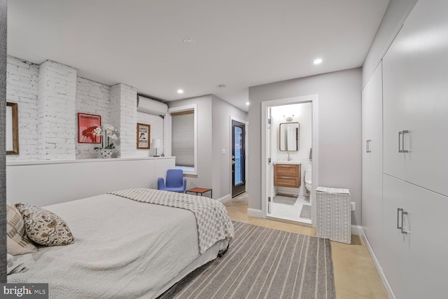 bedroom with a wall unit AC, recessed lighting, baseboards, and ensuite bathroom