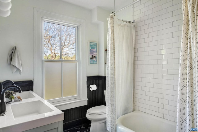 bathroom with toilet, a sink, shower / bath combo with shower curtain, and tile patterned flooring