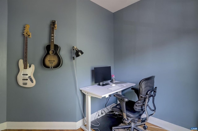 home office with baseboards and wood finished floors