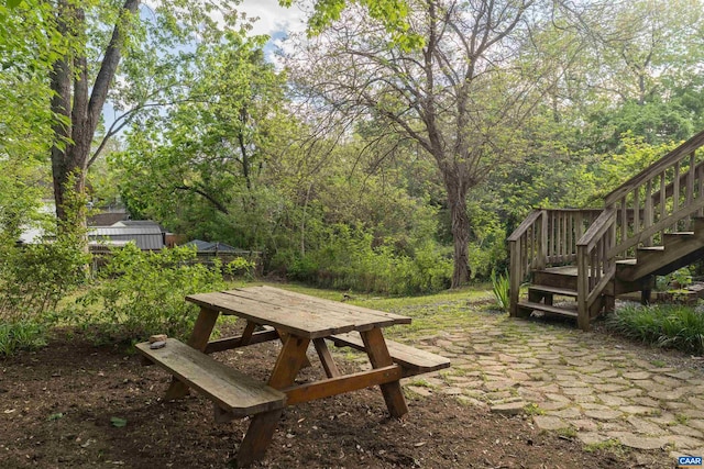 view of yard featuring stairway and a wooded view