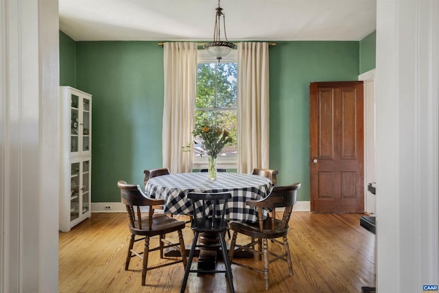 dining area featuring light wood finished floors and baseboards