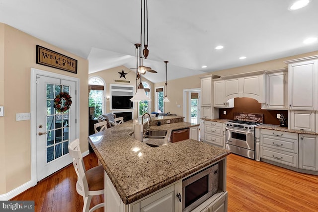 14535 Honeysuckle, Issue, MD 20645 - kitchen featuring appliances with stainless steel finishes, a sink, a center island with sink, light stone counters, and open floor plan