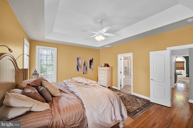 14535 Honeysuckle, Issue, MD 20645 - bedroom featuring a tray ceiling, multiple windows, wood finished floors, and baseboards