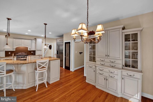 14535 Honeysuckle, Issue, MD 20645 - kitchen featuring premium appliances, light wood-style floors, light stone counters, and recessed lighting