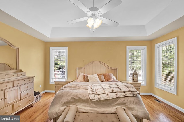 14535 Honeysuckle, Issue, MD 20645 - bedroom featuring a raised ceiling, light wood-style flooring, baseboards, and a ceiling fan