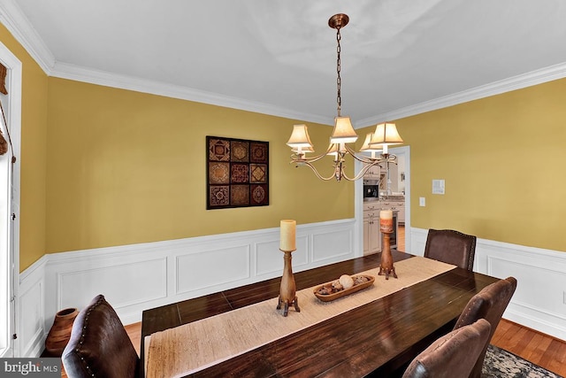 14535 Honeysuckle, Issue, MD 20645 - dining room featuring a chandelier, ornamental molding, a wainscoted wall, wood finished floors, and a decorative wall