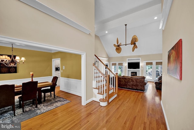 14535 Honeysuckle, Issue, MD 20645 - foyer entrance with a chandelier, high vaulted ceiling, light wood finished floors, stairway, and a wainscoted wall