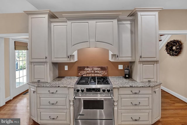 14535 Honeysuckle, Issue, MD 20645 - kitchen with high end range, white cabinets, light wood-type flooring, and light stone counters