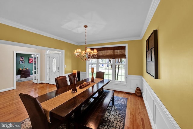 14535 Honeysuckle, Issue, MD 20645 - dining space featuring ornamental molding, a chandelier, light wood finished floors, wainscoting, and a decorative wall