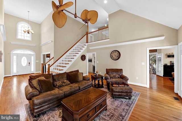 14535 Honeysuckle, Issue, MD 20645 - living room with high vaulted ceiling, stairway, wood finished floors, baseboards, and a chandelier