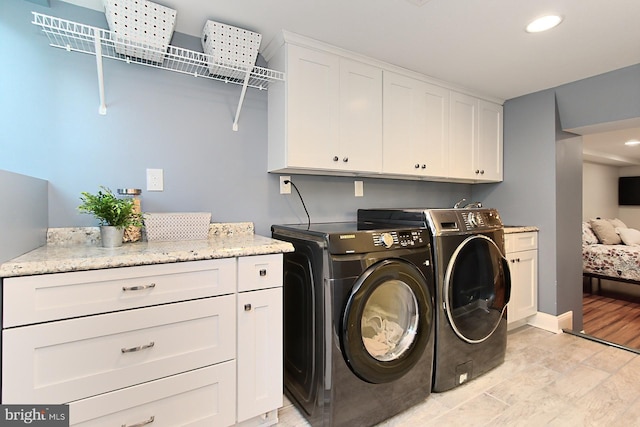 laundry area featuring washing machine and dryer, cabinet space, baseboards, and recessed lighting