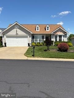 view of front of home featuring driveway, a garage, and a front yard