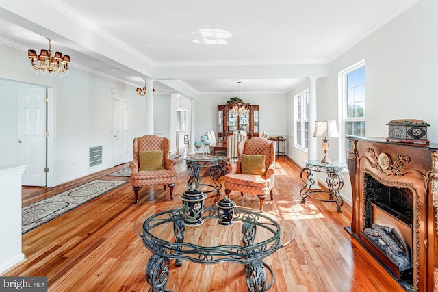 16453 Sparkling Brook Loop, Dumfries, VA 22025 - living room with light wood finished floors, a chandelier, decorative columns, crown molding, and a high end fireplace