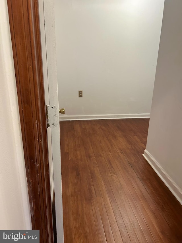 unfurnished room with baseboards and wood finished floors