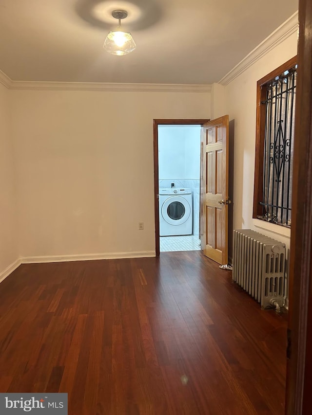 unfurnished room with radiator heating unit, washer / dryer, crown molding, dark wood-style floors, and baseboards