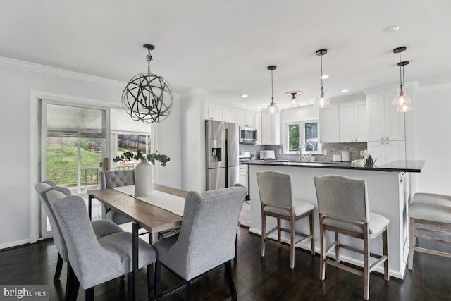 dining area featuring dark wood finished floors, crown molding, recessed lighting, and a chandelier