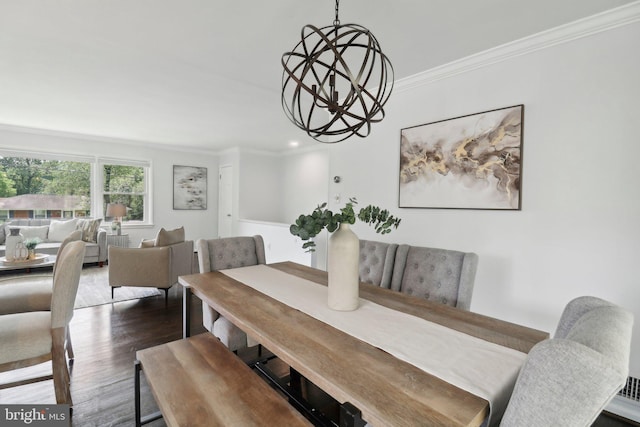 dining area featuring a chandelier, ornamental molding, and wood finished floors