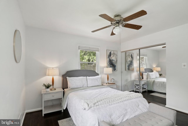 bedroom with a closet, baseboards, wood finished floors, and a ceiling fan