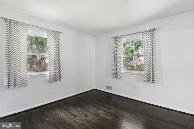 empty room featuring wood finished floors and baseboards