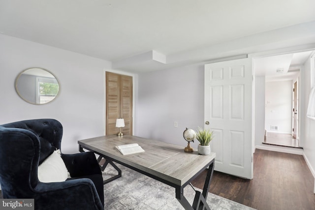 office area with dark wood-style flooring and baseboards