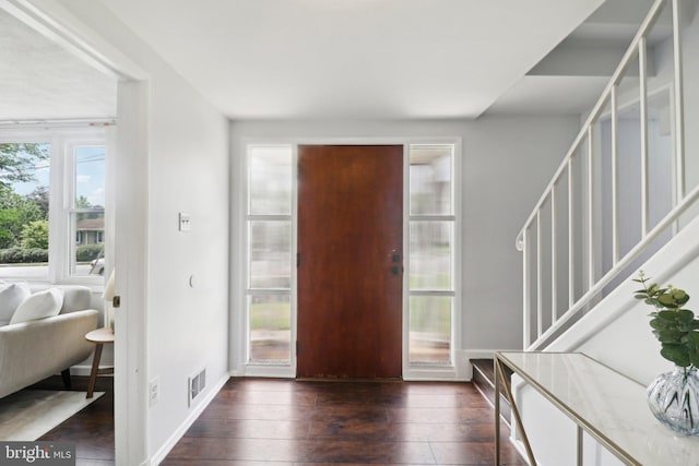 entrance foyer featuring stairs, dark wood finished floors, and baseboards