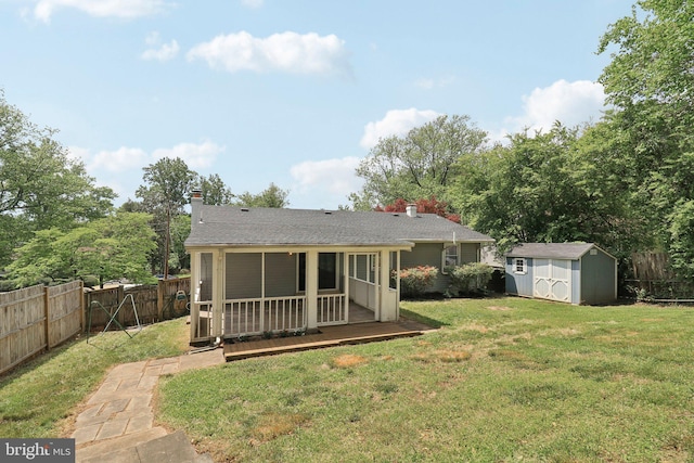 rear view of property featuring a storage shed, an outdoor structure, a deck, a chimney, and a shingled roof