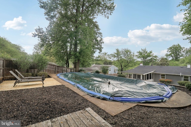 view of pool with a fenced backyard, a patio, and a deck