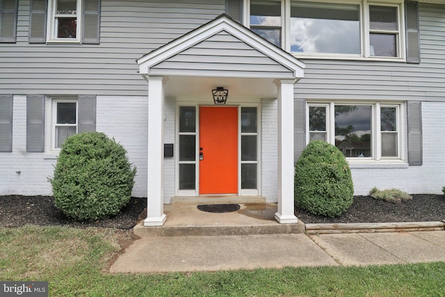 doorway to property featuring brick siding