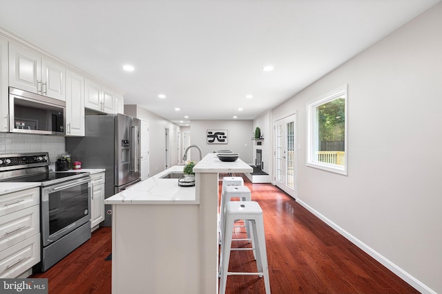 194 Black Cub Run Ln, Harpers Ferry, WV 25425 - kitchen with appliances with stainless steel finishes, a sink, dark wood-style flooring, a breakfast bar, and a kitchen island with sink