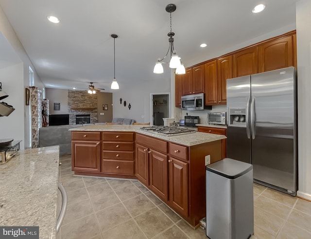 13605 Sugar Mill Ct, Waldorf, MD 20601 - kitchen with appliances with stainless steel finishes, ceiling fan, a stone fireplace, open floor plan, and hanging light fixtures