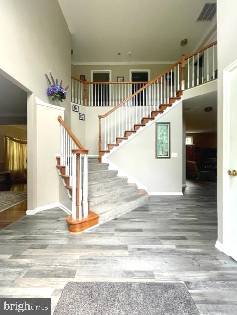 13605 Sugar Mill Ct, Waldorf, MD 20601 - stairs with wood finished floors, a towering ceiling, baseboards, and ornamental molding