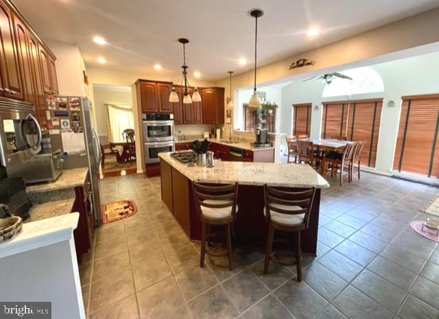 13605 Sugar Mill Ct, Waldorf, MD 20601 - kitchen with stainless steel appliances, a kitchen island, ceiling fan, tile patterned floors, and recessed lighting