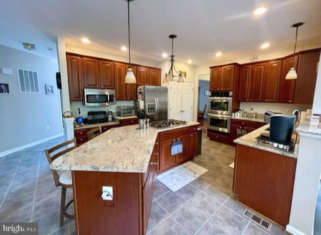 13605 Sugar Mill Ct, Waldorf, MD 20601 - kitchen featuring appliances with stainless steel finishes, recessed lighting, a kitchen island, light stone counters, and a kitchen breakfast bar