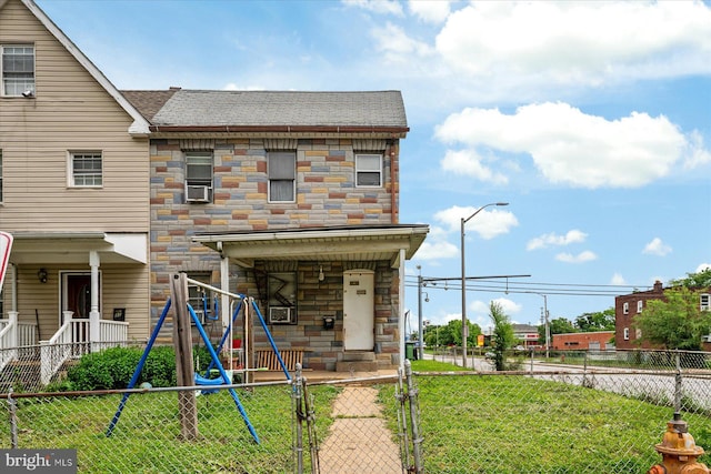 28 Talbott St, Baltimore, MD 21225 - back of house featuring stone siding, a gate, roof with shingles, and a playground