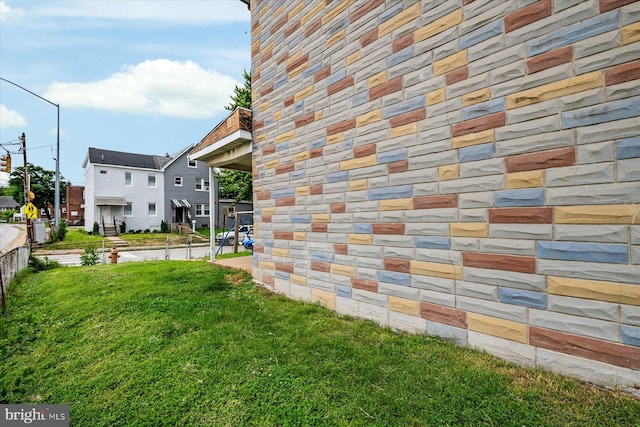28 Talbott St, Baltimore, MD 21225 - view of home's exterior featuring stone siding and a lawn
