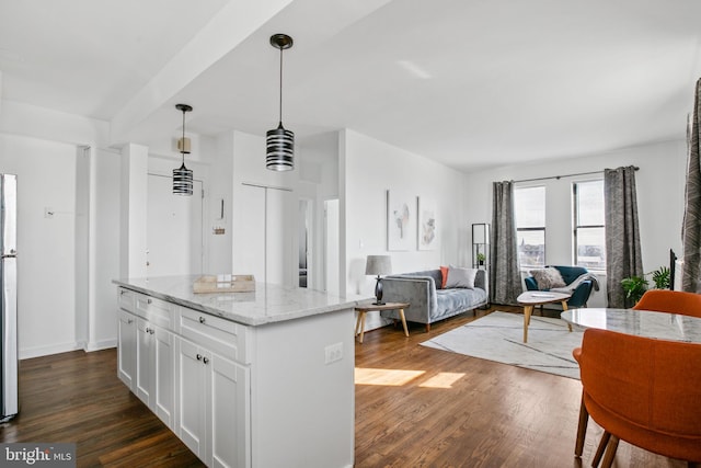 1001 Saint Paul St Unit 9F, Baltimore, MD 21202 - kitchen featuring dark wood-type flooring, white cabinets, hanging light fixtures, a kitchen island, and light stone countertops