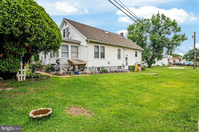 216 Charles St, Baltimore, MD 21225 - rear view of house featuring a shingled roof and a lawn
