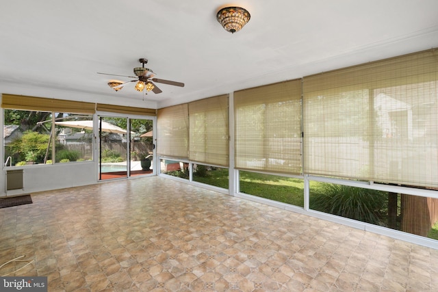 unfurnished sunroom featuring ceiling fan