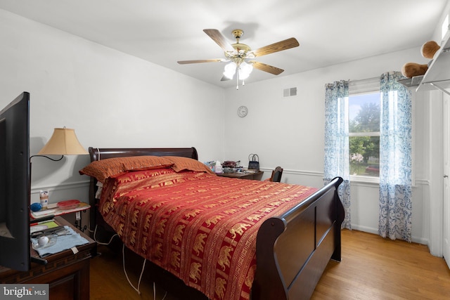 bedroom featuring wood finished floors, baseboards, and a ceiling fan