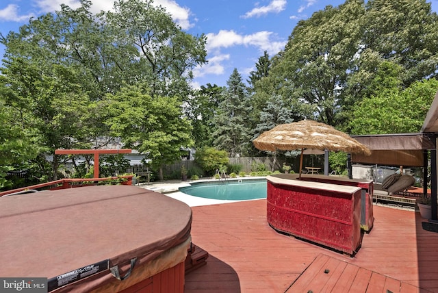 view of swimming pool with a covered hot tub, a deck, and a fenced backyard