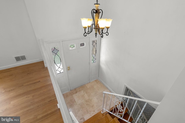 entrance foyer featuring a chandelier, baseboards, and light wood finished floors