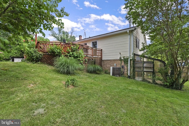 view of grassy yard with central AC unit and a wooden deck
