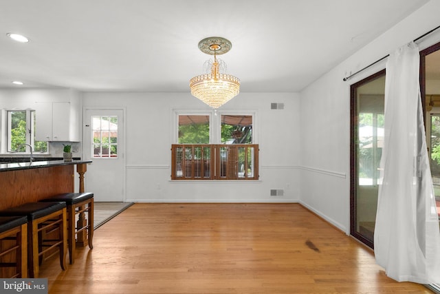 dining room featuring a chandelier, light wood-type flooring, recessed lighting, and baseboards