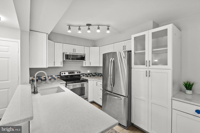 2224 Springwood Dr Unit 102A, Reston, VA 20191 - kitchen featuring appliances with stainless steel finishes, a sink, white cabinetry, and glass insert cabinets