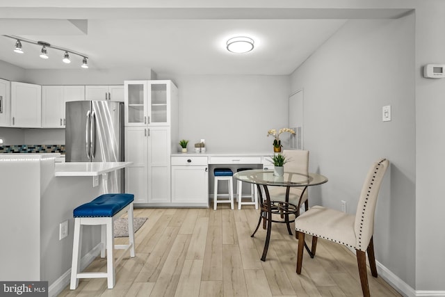 2224 Springwood Dr Unit 102A, Reston, VA 20191 - kitchen with freestanding refrigerator, white cabinets, a kitchen breakfast bar, glass insert cabinets, and light countertops