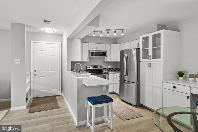 2224 Springwood Dr Unit 102A, Reston, VA 20191 - kitchen with stainless steel appliances, light wood-style floors, white cabinetry, and glass insert cabinets