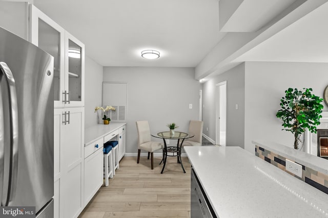 2224 Springwood Dr Unit 102A, Reston, VA 20191 - kitchen featuring stainless steel appliances, light wood finished floors, white cabinetry, glass insert cabinets, and light stone counters