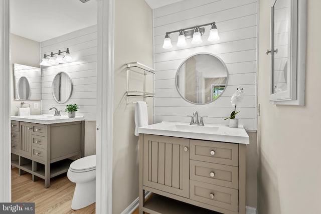 2224 Springwood Dr Unit 102A, Reston, VA 20191 - bathroom with wood finished floors, wooden walls, two vanities, and toilet